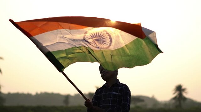 Indian Flag Waving in Slow Motion with Sunset Backlight Outdoors. Patriotic Concept Video Featuring Indian Tricolor Flag Waving Proudly. India Independence Day.