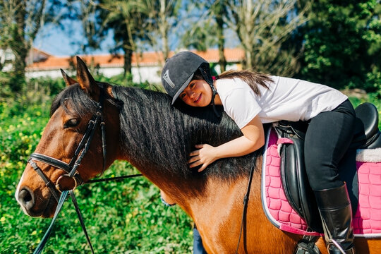 Teenager with down syndrome riding a horse