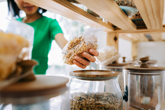 Customer shopping for organic granola in a zero waste grocery store