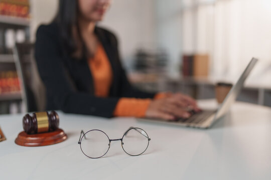 Lawyer working on laptop with gavel and glasses