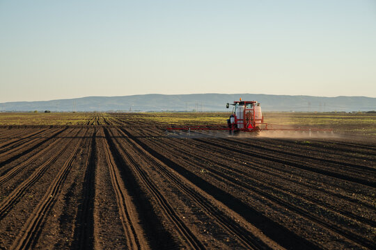 Agricultural field sprayer applying herbicide on cultivated farmland