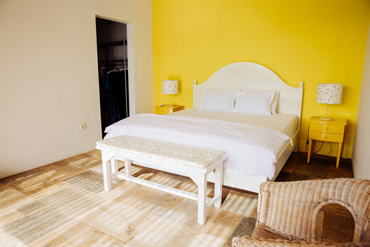 Indonesia, Bali, bedroom with yellow wall and yellow bedside cabinets of a holiday villa