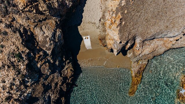 Aerial view shows a secluded beach cove with turquoise sea