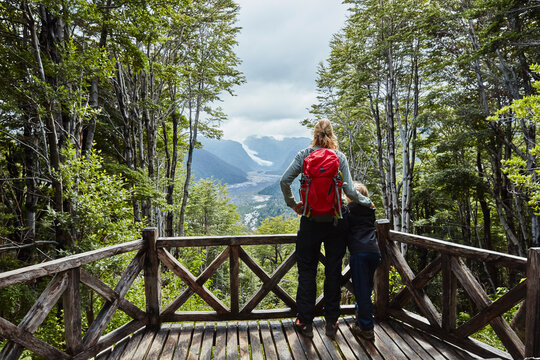 Chile, Chaiten, Parque Pumalin, mother and son on observation deck looking at glacier