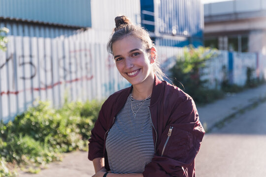 Smiling woman stands outdoors in the city wearing a casual jacket