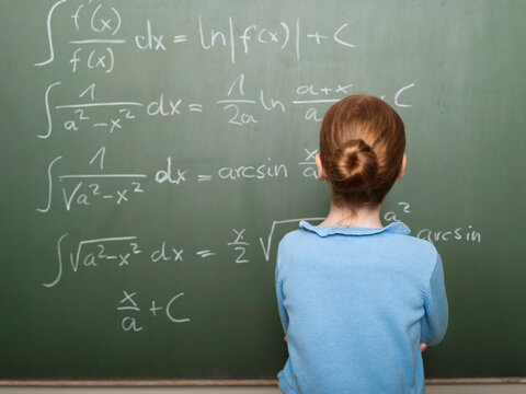 Student looking at complex math equations on a chalkboard