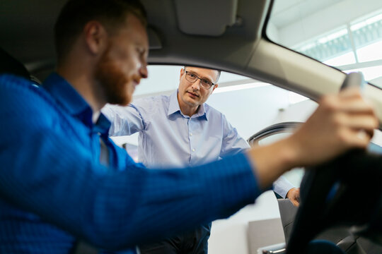Customer in car dealership testing car