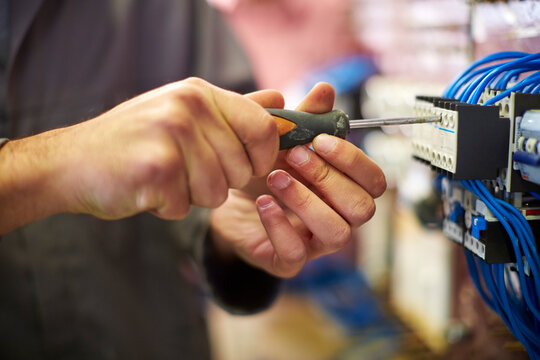 Close-up of electrician working with screw driver
