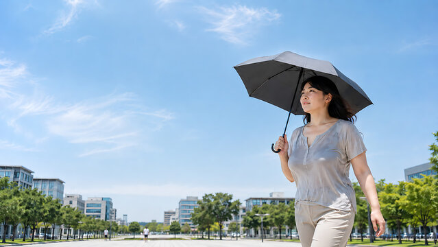 暑い夏の日に日差しを避ける傘を差して歩く日本人女性