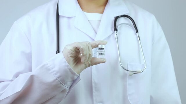 Confident professional doctor wearing white coat holding vaccine vial with stethoscope showcases medical science research for human longevity
