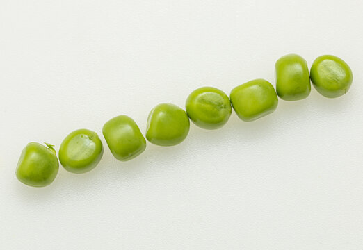 Fresh green peas lie in a straight line