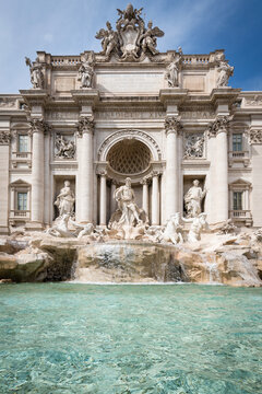 Perfectly symmetrical vertical view of the majestic Trevi Fountain with clear turquoise water in Rome, Italy