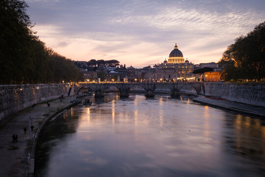 Beautiful twilight view of St. Peter's Basilica dome and Ponte Sant'Angelo bridge over the Tiber River at sunset in Rome, Italy