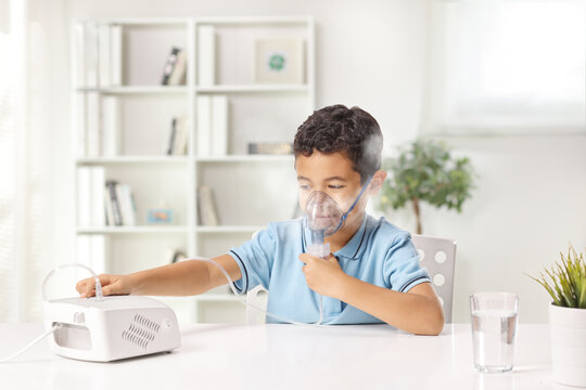 Little boy using a nebulizer machine with an inhalation mask