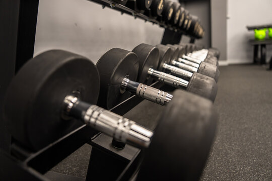 Dumbbells and kettlebells arranged in a modern gym, highlighting strength training equipment used for fitness, bodybuilding, endurance, and functional workout routines.