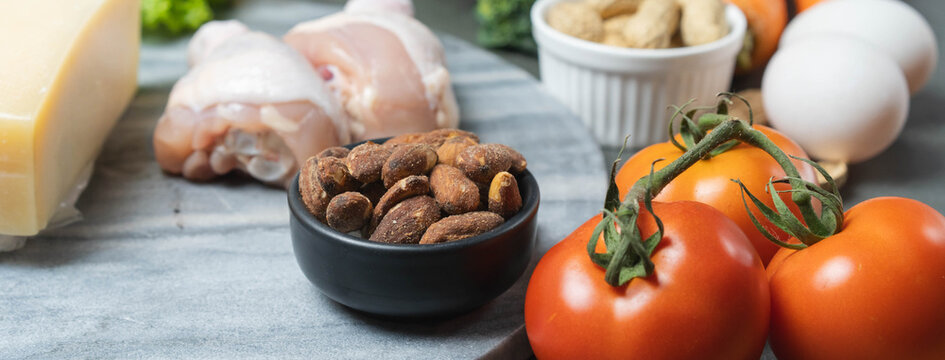 Ketogenic diet ingredients with chicken, eggs, cheese, tomatoes and nuts.