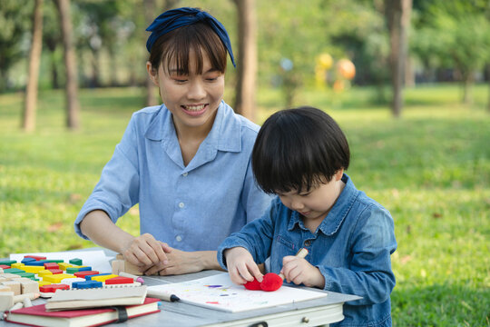 Mother and child bonding over drawing activity during a weekend picnic in a park