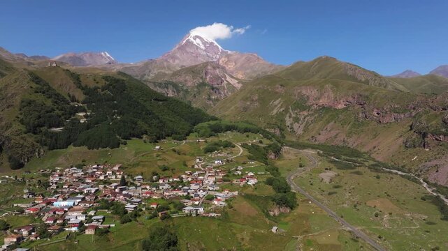 Aerial drone panorama of Stepantsminda village with Mount Kazbek in Georgia.