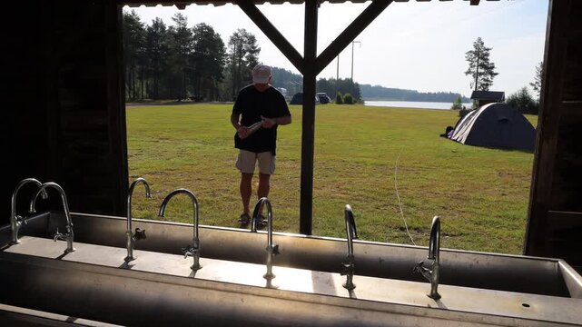 Idre, Sweden A man tries to fetch fresh water for a thermos from broken outdoor faucets at a campsite. 