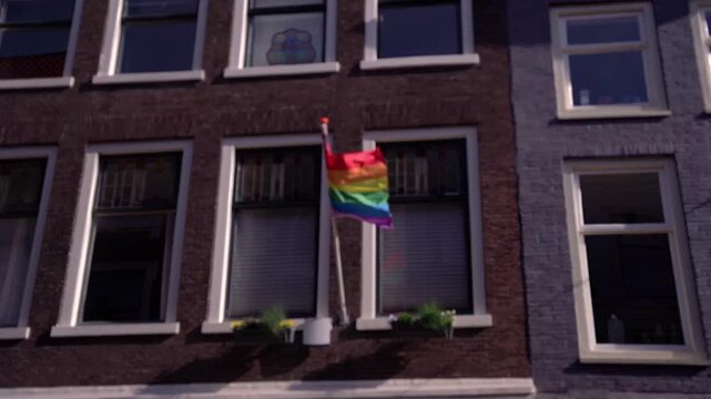 LGBT Pride Flag Displayed on a Traditional Brick Building in Dordrecht, Netherlands, Symbolizing Inclusion and Diversity.