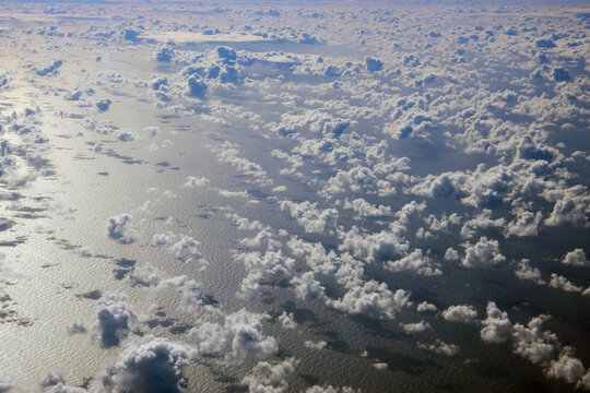 Cloud formations are reflected on the surface of the ocean in the early morning.