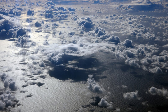 Cloud formations are reflected on the surface of the ocean in the early morning.