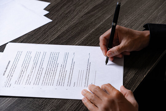 Hand Using Fountain Pen to Sign Last Will and Testament Legal Document