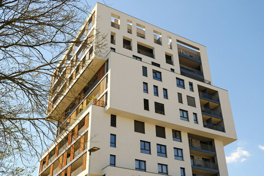 Modern residential building with geometric architecture and blue sky. Real estate, urban development, and contemporary city living concepts.