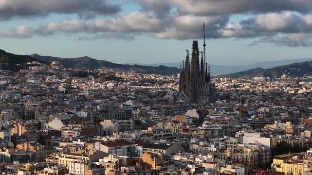 Drone Shot of Barcelona Spain and Sagrada Familia Cathedral Raising Above Downtown Buildings