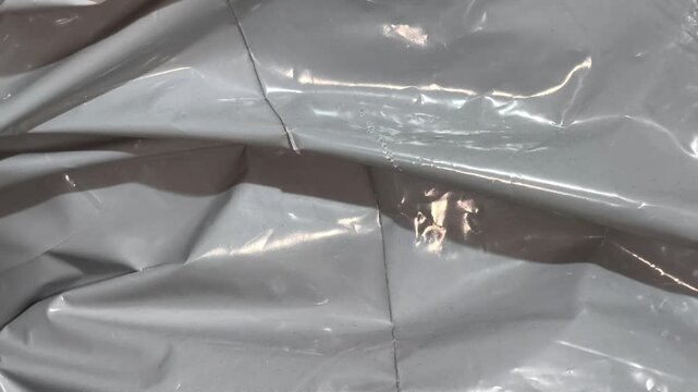 Crumpled Gray Plastic Texture with Damaged Hole and Wrinkled Mailing Bag Surface