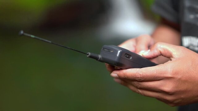 Operating a 90s mobile phone, a communication device that still relied on an antenna to pick up a signal.