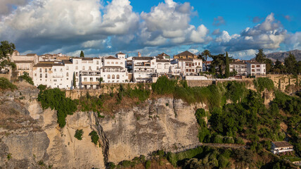 Fototapeta premium Vista de las casas colgantes sobre barranco en el hermoso pueblo blanco de Ronda, Andalucía, España. Cielo editado