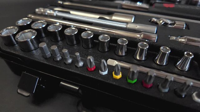 Camera moves left to right revealing ratchet socket and driver bit kit in organized layout.