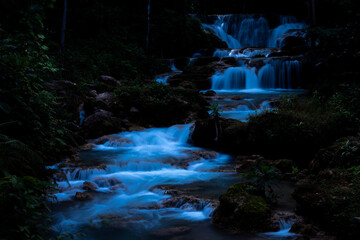 Serene Cascading Waterfall Flows Through Lush Tropical Jungle At Huai Mae Khamin Waterfall In Thailand During A Peaceful Night © SHUTTER DIN