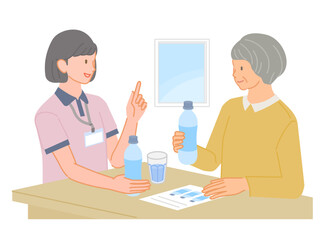 Obraz premium 医療スタッフから水分補給の説明を受けるシニア女性
