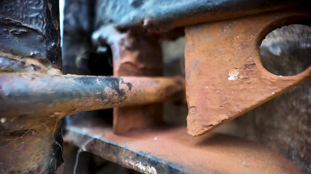 Close-up view of a heavily corroded and weathered gate latch, highlighting the texture and signs of age.