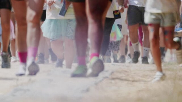 Participants run in colorful socks during fun run event in a sunny park