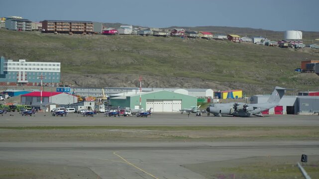Ground-level telephoto shot of French Air Force Patrouille de France Alphajet trainers lining up alongside a giant Airbus A400M Atlas transport aircraft for a trans-Atlantic refueling stop in Nunavut.