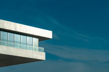 Modern Mediterranean architecture. Minimalist image of a white building cornice with glass. Blue sky and copy space © Inspiraciones