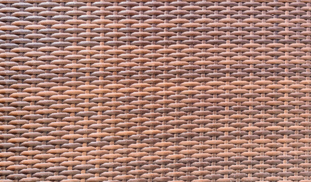Brown synthetic rattan texture background woven plastic wicker pattern for garden furniture