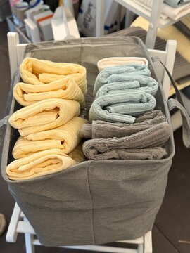Rolled towels in fabric basket for organized bathroom storage, background in home decor settings