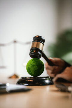Judge's gavel above a green globe symbolizing environmental law, ESG compliance, climate justice, and sustainable governance.