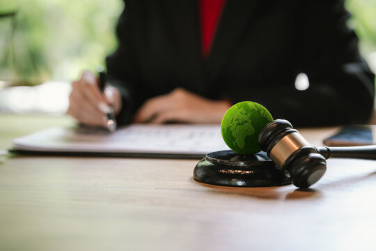Judge's gavel above a green globe symbolizing environmental law, ESG compliance, climate justice, and sustainable governance.