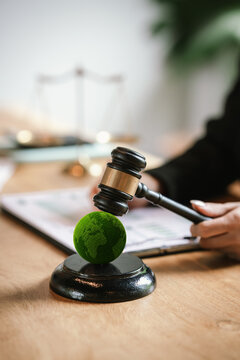 Judge's gavel above a green globe symbolizing environmental law, ESG compliance, climate justice, and sustainable governance.