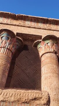 Intricate hieroglyphs and colorful details decorating the massive sandstone columns of the esna temple, a preserved ancient egyptian ruin