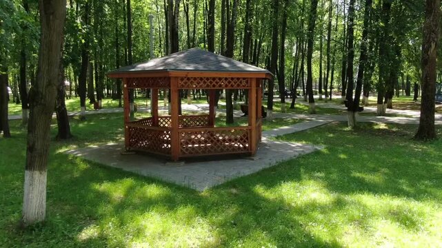 Drone orbiting gazebo amid Korolev forest park