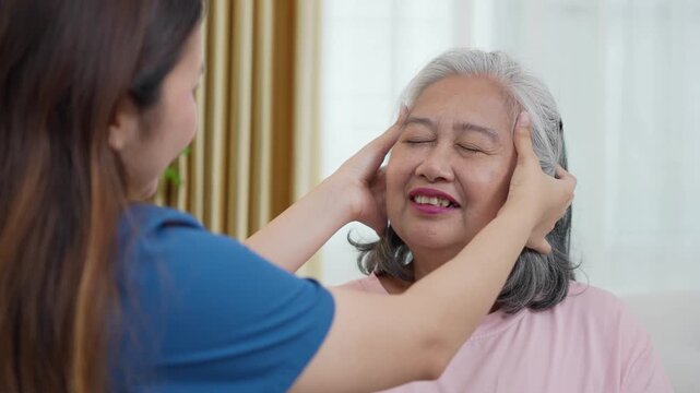 Caregiver giving head massage to senior woman for relaxation, Professional nurse performing temple massage for elderly patient, Gentle head massage for stress relief and relaxation in senior care