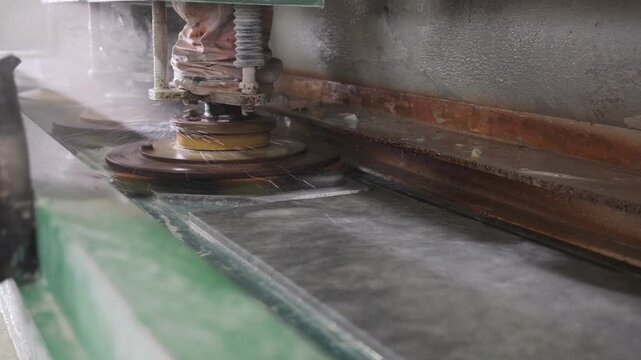 Industrial machinery polishing marble slab with water in stone factory