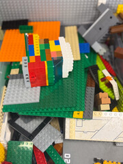 Fototapeta premium Colorful lego bricks and plates piled together in a close-up view, showing a mix of shapes, textures, and bright colors for creative play and building.