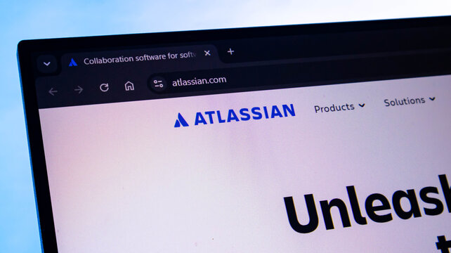 Close up view of atlassian.com homepage on a laptop screen displaying company's logo and website address.